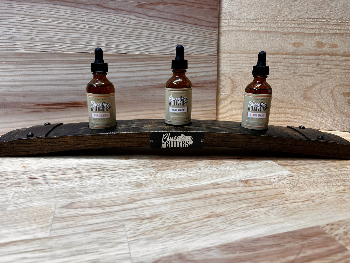 Three dropper bottles on a wooden barrel stave with a brand label.  Bottles sold separately.  